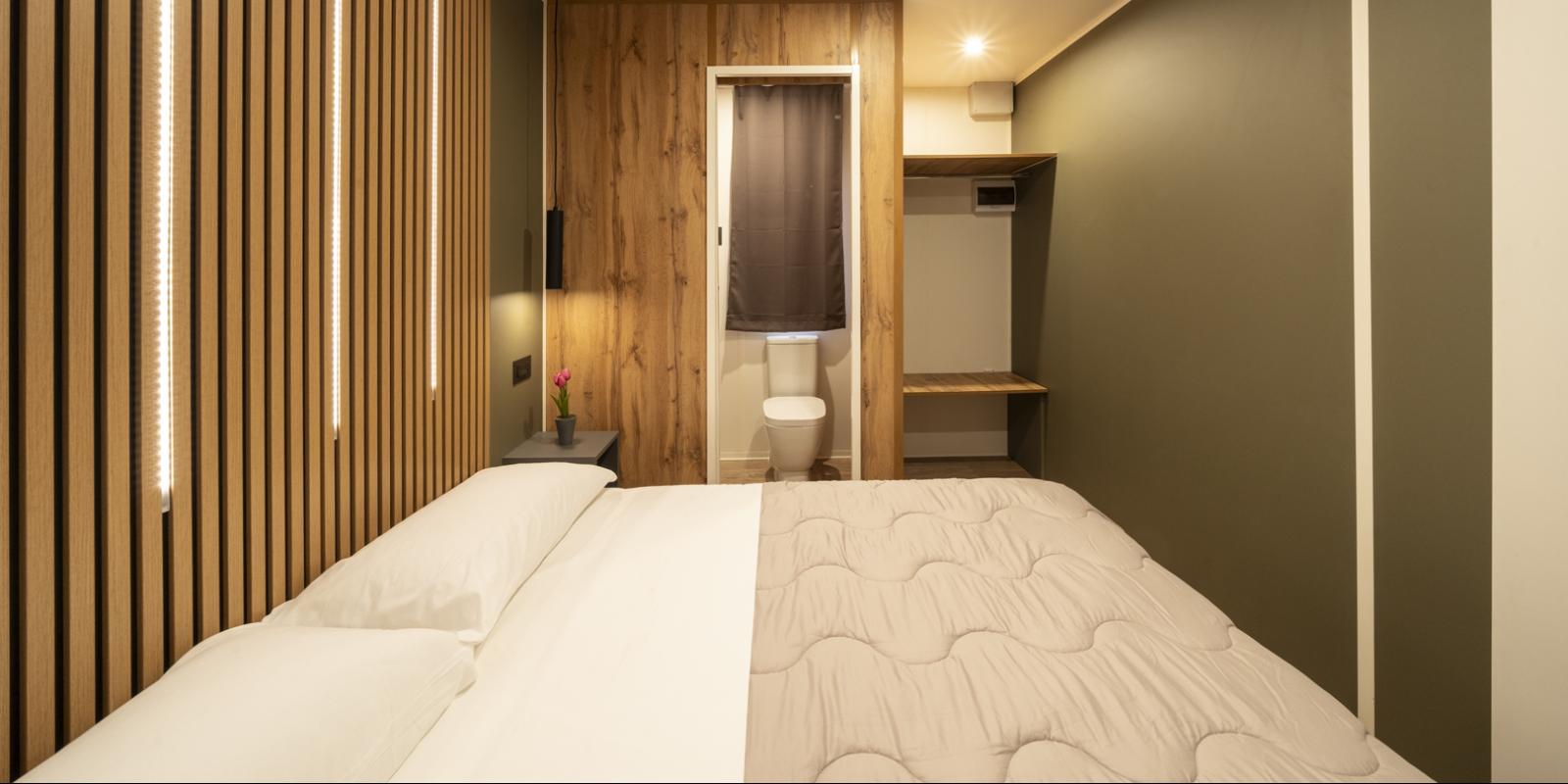 Chambre moderne avec lit, bois et salle de bain.