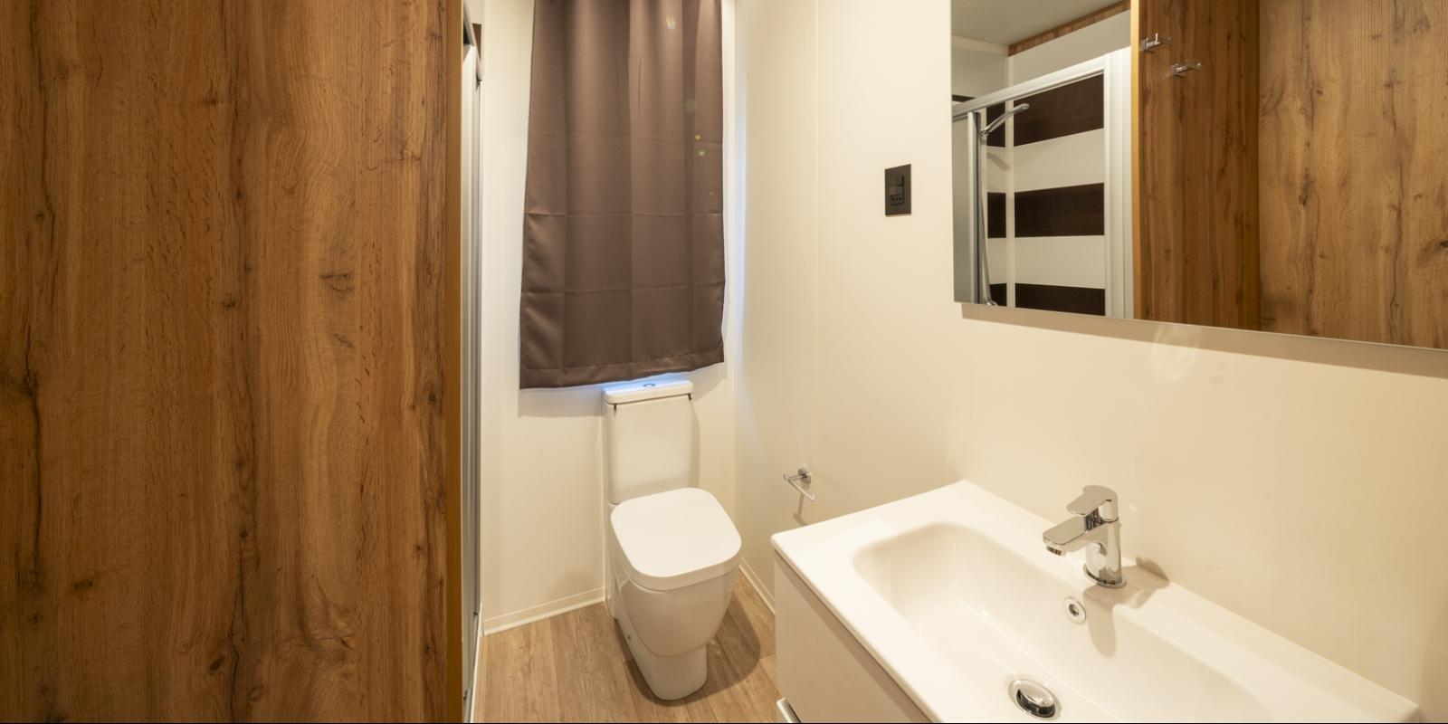 Salle de bain moderne avec bois et éclairage minimaliste.