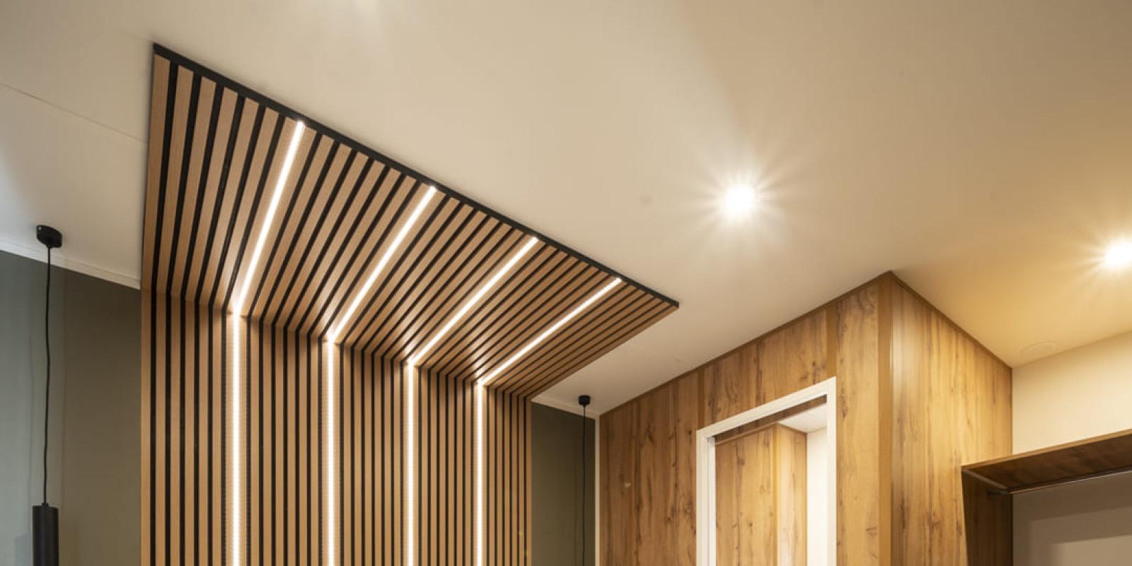 Chambre moderne avec éclairage à bandes et décor en bois.