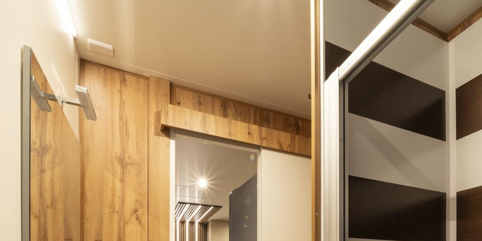 Salle de bain moderne avec douche et sol en bois.