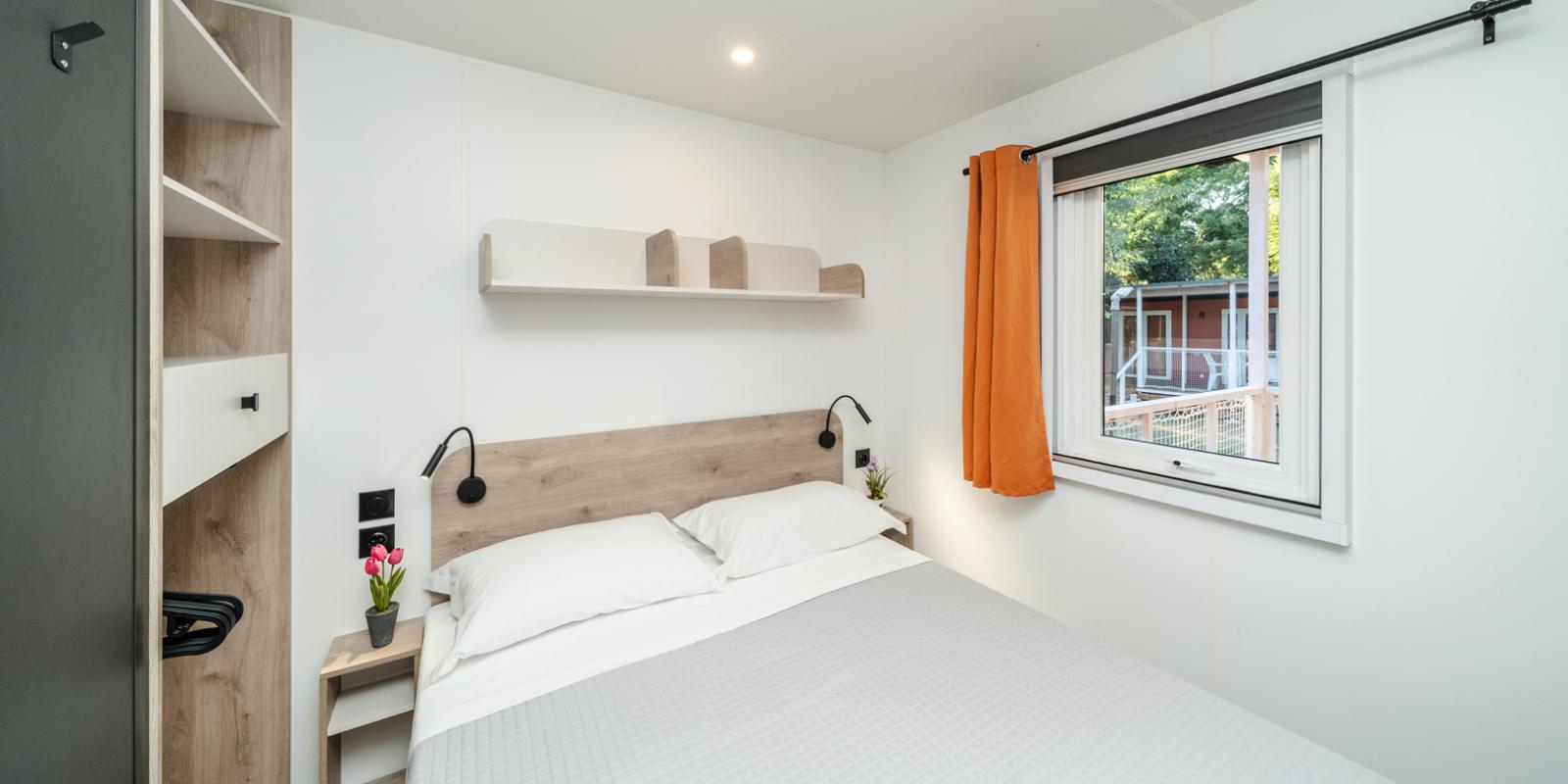 Modernes Schlafzimmer mit Doppelbett und Fenster.