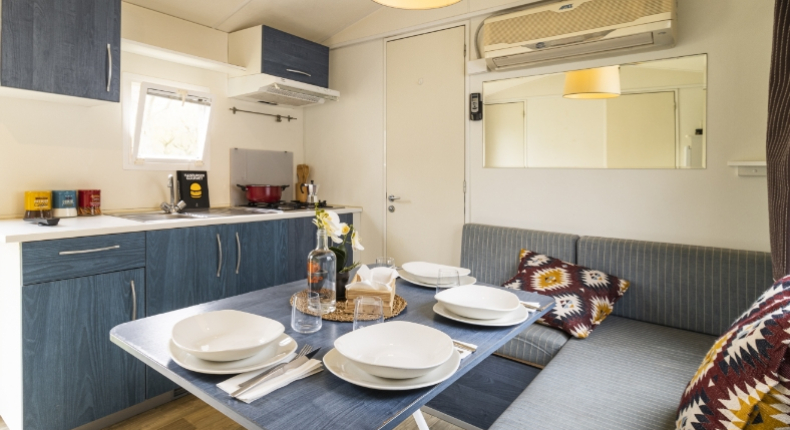 Cucina moderna con tavolo apparecchiato, sedute comode e decorazioni colorate.